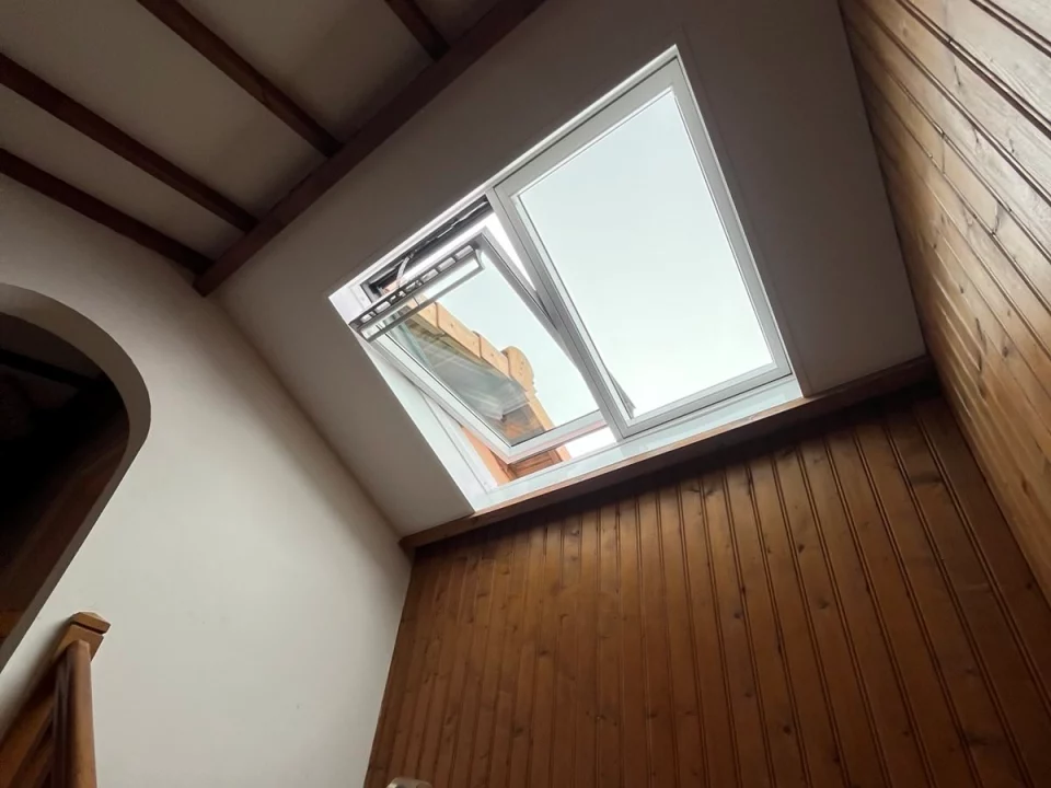 verrière 2 en 1 VELUX dans une cage d'escalier avec du lambris